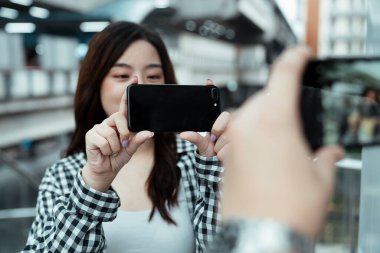 Genç çift, mutlulukla buluşurken birbirlerine fotoğraf çekiyorlar..