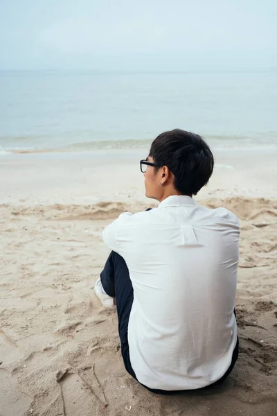Black Hair Guy White Shirt Sitting Back Camera Beach Look — Stock Photo, Image