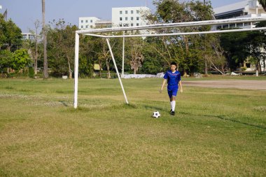 Genç çocuk kalenin önünde topa vuracak..