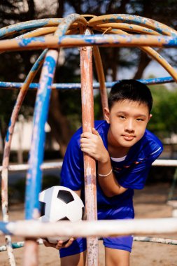 Mavi bir çocuk ve futbol parktaki tırmanma sahasında..