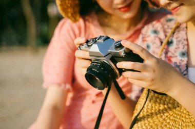 Fotoğrafa bakarken kızın ellerinde kesilmiş görüntü kayıt kamerası var..