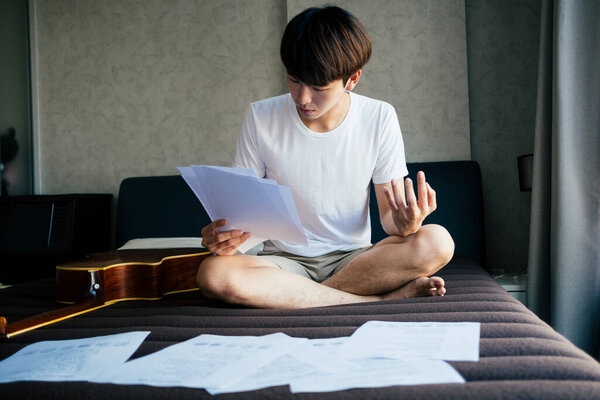 Young Thai Guitarist Man Reading Music Lyric Paper Practice Fingers Royalty Free Stock Photos