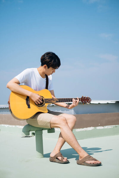 Young Thai Guitarist Man Sitting Tube Playing Acoustic Guitar Rooftop Royalty Free Stock Images