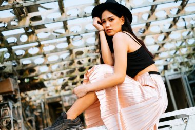 Siyah ve pembe elbiseli uzun saçlı kız enkaz uçağında havalı duruşu olan bir süpermodel gibi fotoğraf çekiyor..