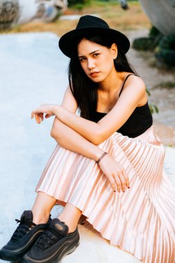 Siyah ve pembe elbiseli kadın terk edilmiş bölgede uçak enkazı için tek başına oturuyor..