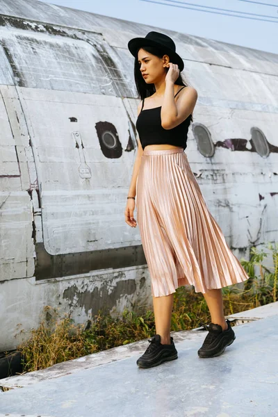 Siyah ve pembe elbiseli kadın enkaz uçağının yanında yürüyor..