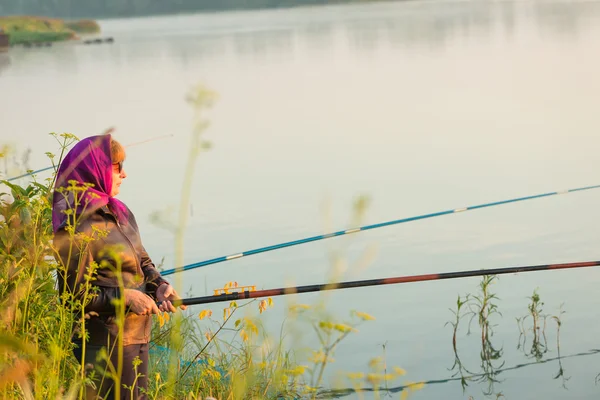 Donna pesca sulla riva del fiume — Foto Stock