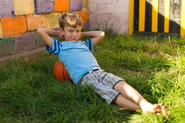Chłopiec piłkę do koszykówki na trawie — Zdjęcie stockowe