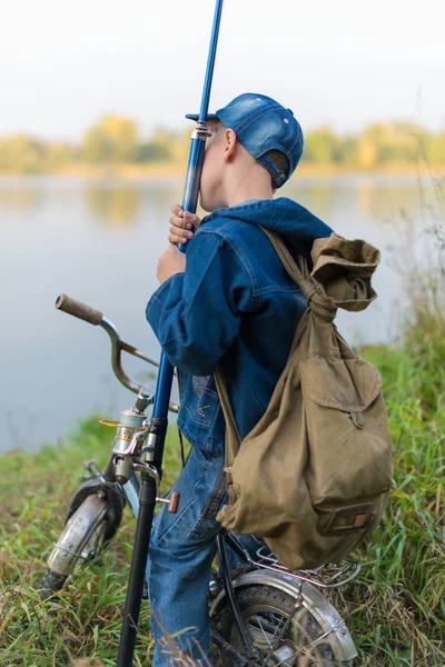 Ragazzo viaggia con uno zaino sulla riva del fiume — Foto Stock