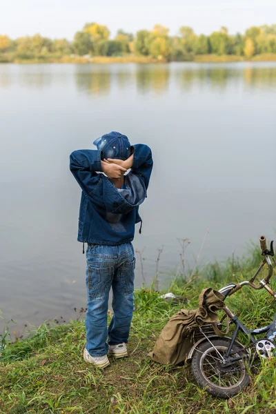 Ragazzo viaggia con uno zaino sulla riva del fiume — Foto Stock