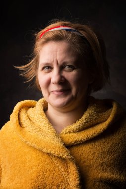 Yüzünde duygu olan bir adamın fotoğrafı. Ev eşyaları sarı renktedir. Sıcak bornoz kurtuluşu soğuktan.