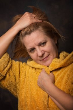 Yüzünde duygu olan bir adamın fotoğrafı. Ev eşyaları sarı renktedir. Sıcak bornoz kurtuluşu soğuktan.