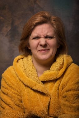 Yüzünde duygu olan bir adamın fotoğrafı. Ev eşyaları sarı renktedir. Sıcak bornoz kurtuluşu soğuktan.