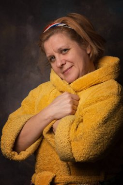 Yüzünde duygu olan bir adamın fotoğrafı. Ev eşyaları sarı renktedir. Sıcak bornoz kurtuluşu soğuktan.