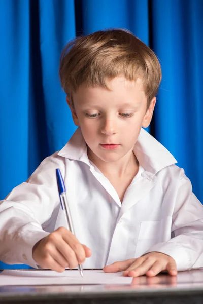 Chlapec píše na jeden list papíru — Stock fotografie