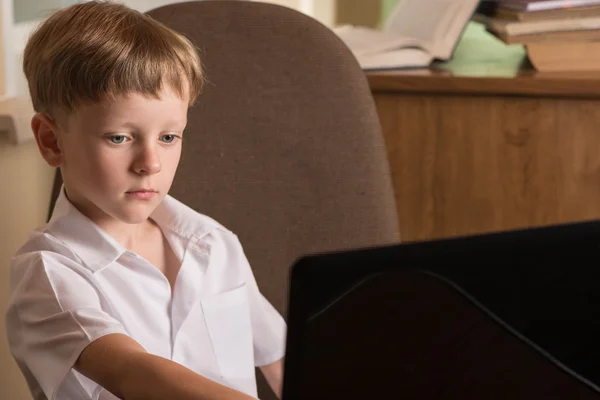 Junge mit Laptop am Tisch — Stockfoto