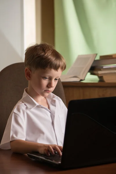 Junge mit Laptop am Tisch — Stockfoto