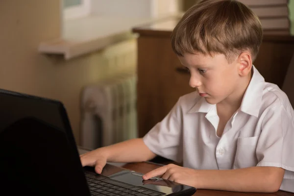 Junge mit Laptop am Tisch — Stockfoto