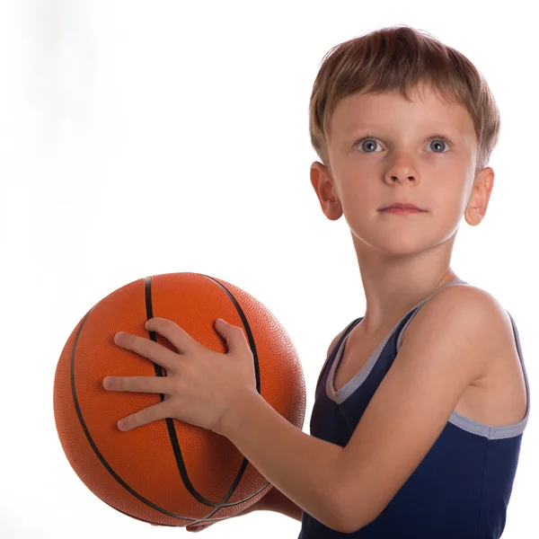 El niño lanzó una pelota de baloncesto de dos manos —  Fotos de Stock