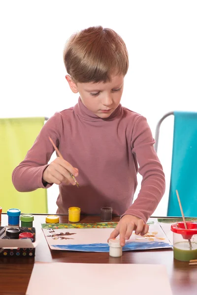 The boy drew a water color on a paper a brush Royalty Free Stock Images