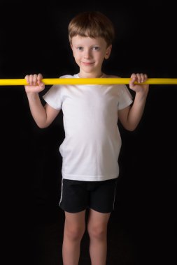 Çocuk atlet spor salonunda egzersiz jimnastik sopayla gerçekleştirir