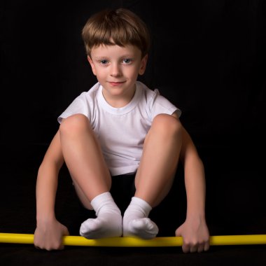 Çocuk atlet spor salonunda egzersiz jimnastik sopayla gerçekleştirir