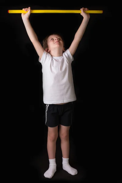 Chłopiec sportowiec wykonuje ćwiczenia gimnastyczne kijem w siłowni — Zdjęcie stockowe