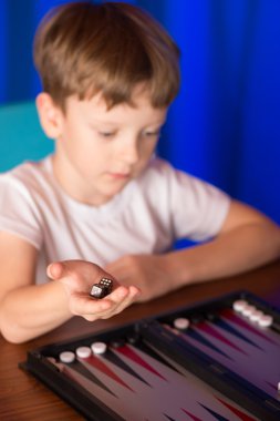 boy playing a board game called Backgammon clipart
