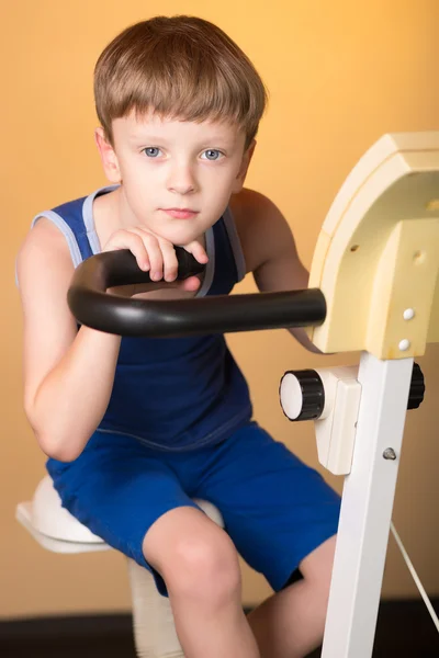 The child is trained on a stationary bike . Healthy lifestyle.