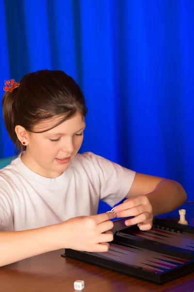 Dívka si hraje desková hra jako Backgammon — Stock fotografie