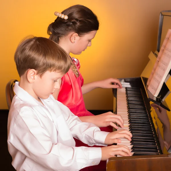 Αδελφός και αδελφή, παίζει πιάνο. Εκτελεστής πιάνου. — Φωτογραφία Αρχείου