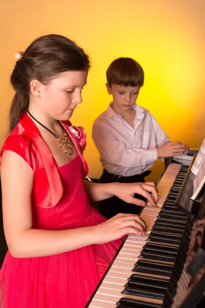 Hermano y hermana tocando el piano. Pianista . —  Fotos de Stock