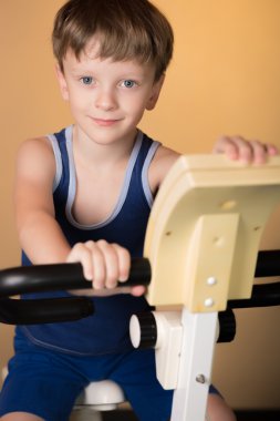 Çocuk üzerinde sabit bir bisiklet eğitimli. Sağlıklı yaşam tarzı.