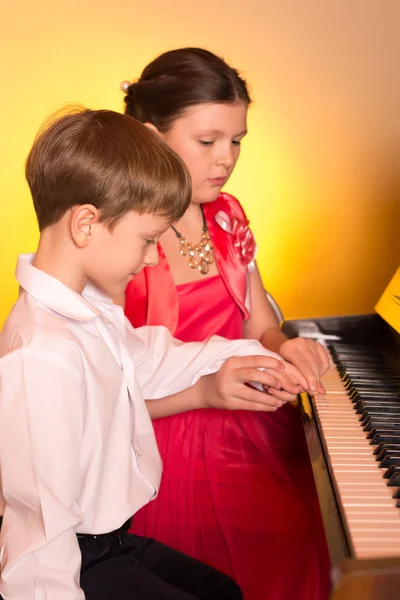 Αδελφός και αδελφή, παίζει πιάνο. Εκτελεστής πιάνου. — Φωτογραφία Αρχείου