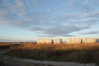 Yeni yazlık evlere giden kirli bir yol. Evleri ve güzel gökyüzü olan dış yol manzarası