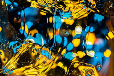 Akan büyük kabarcıklar ve mavi, siyan ve sarı renkli Bokeh ışıkları ile soyut sıvı arka plan bulanıklığı. Yuvarlak saydam geometrik parçacıklara sahip gizemli arkaplan, seçici odak