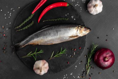 Siyah arka planda sebzeli ringa balığı, balık pazarı kavramı.