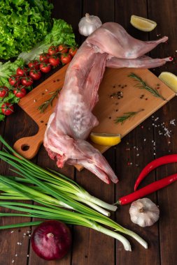 Tahta kesme tahtasının üzerinde taze kırmızı tavşan eti, yan görüş.