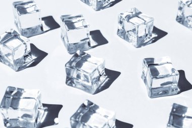 Öğle güneşinde bir sürü buz kübü ve arka planda sert gölgelerle yaz modelleri.