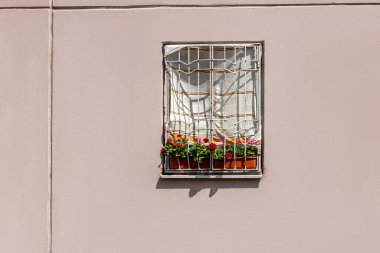Evin penceresi direkt güneş ışığından korunmak için havluyla kaplı. Yazın sıcağında bir daireyi serinletmek için ucuz bir yol.
