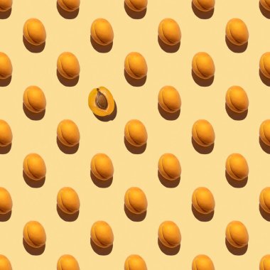 Sarı bir zemin üzerinde izole edilmiş taze turuncu kayısılarla yapılmış desen, boşluğu kopyala