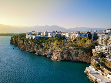 Antalya 'da Antalya Körfezi' nin güneşli bir günde İHA 'nın yüksek noktasından havadan çekilmiş fotoğrafı. Kuşlardan inanılmaz bir şehir manzarası. Güzel kasaba ve deniz yamaçları üzerinde uçuyorlar.