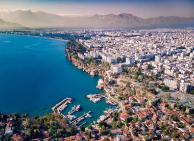 Antalya 'da Antalya Körfezi' nin güneşli bir günde İHA 'nın yüksek noktasından havadan çekilmiş fotoğrafı. Kuşlardan inanılmaz bir şehir manzarası. Güzel kasaba ve deniz yamaçları üzerinde uçuyorlar.
