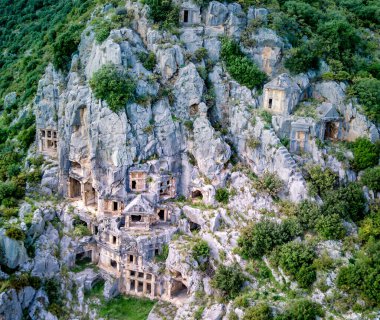 Antik Yunan kayalarının yüksek açılı insansız hava aracı görüntüsü Myra 'daki Lykian İmparatorluğu amfi tiyatro ve mezarlarını kesti (Demre, Türkiye)