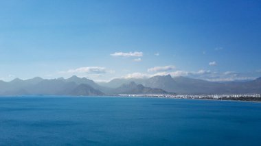 Antalya 'da Antalya Körfezi' nin güneşli bir günde İHA 'nın yüksek noktasından havadan çekilmiş fotoğrafı. Kuşlardan inanılmaz bir şehir manzarası. Güzel kasaba ve deniz yamaçları üzerinde uçuyorlar.