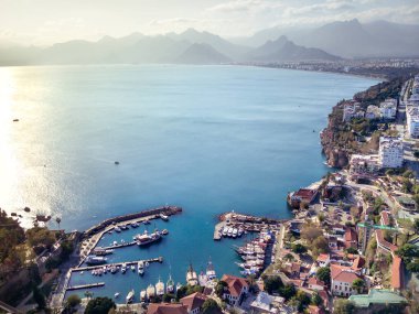 Antalya 'da Antalya Körfezi' nin güneşli bir günde İHA 'nın yüksek noktasından havadan çekilmiş fotoğrafı. Kuşlardan inanılmaz bir şehir manzarası. Güzel kasaba ve deniz yamaçları üzerinde uçuyorlar.