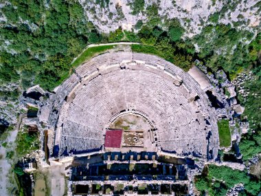 Antik Yunan kayalarının yüksek açılı insansız hava aracı görüntüsü Myra 'daki Lykian İmparatorluğu amfi tiyatro ve mezarlarını kesti (Demre, Türkiye)