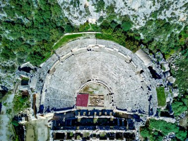 Antik Yunan kayalarının yüksek açılı insansız hava aracı görüntüsü Myra 'daki Lykian İmparatorluğu amfi tiyatro ve mezarlarını kesti (Demre, Türkiye)