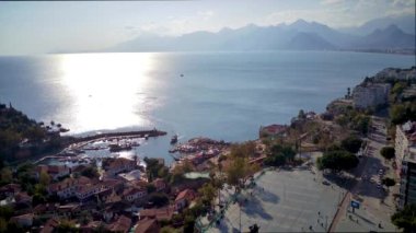 Antalya 'da Antalya Körfezi' nin güneşli bir günde insansız hava aracının yüksek noktasından havadan çekilmiş fotoğrafı. Kuşlardan inanılmaz bir şehir manzarası. Güzel kasaba ve deniz yamaçları üzerinde uçuyorlar.
