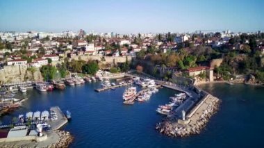 Antalya 'da Antalya Körfezi' nin güneşli bir günde insansız hava aracının yüksek noktasından havadan çekilmiş fotoğrafı. Kuşlardan inanılmaz bir şehir manzarası. Güzel kasaba ve deniz yamaçları üzerinde uçuyorlar.